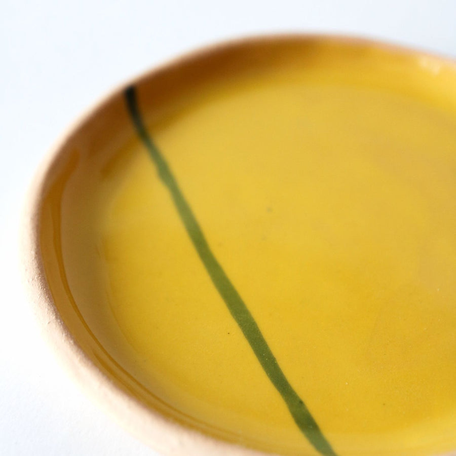 A ceramic plate with a single drawn line running across its face.