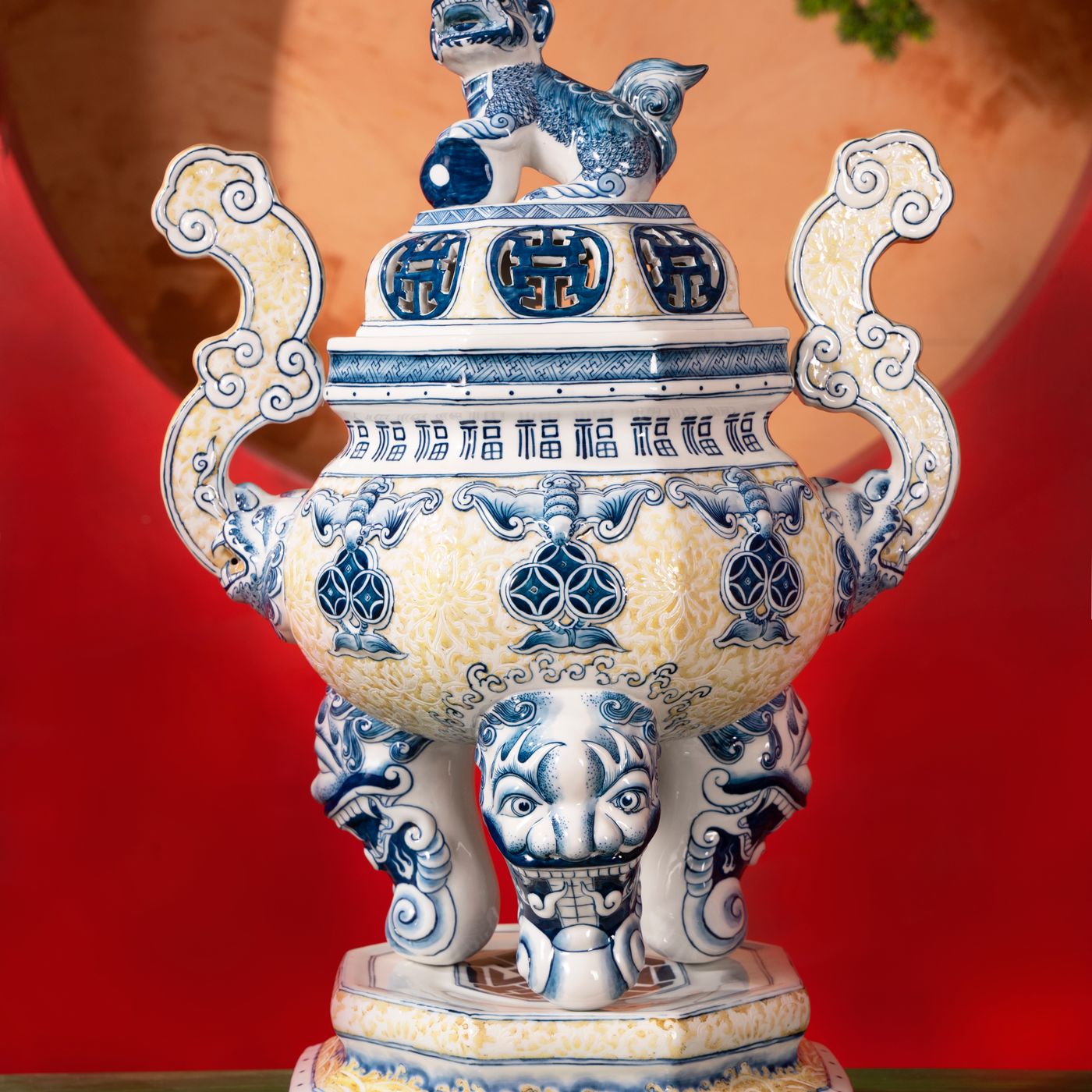 A Chinese porcelain incense burner painted with intricate blue designs in an antique style.