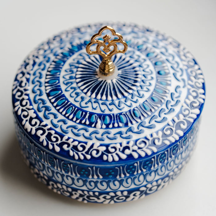 A blue and white ceramic container with close patterning and a lid of its own.