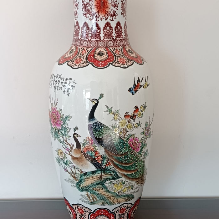 A porcelain vase painted with colourful peacocks and floral motifs.