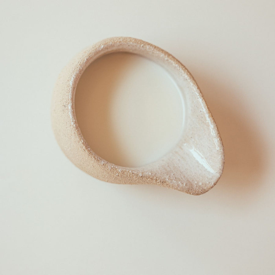 A white ceramic jar standing on a table.